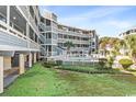 Community pool area with surrounding patio and lawn at 1101 Possum Trot Rd. # C205, North Myrtle Beach, SC 29582