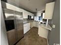 Compact kitchen with white cabinets, stainless steel appliances, and tile floor at 3831 Masters Ct. # 137, Myrtle Beach, SC 29577