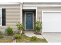 Charming front entrance with a blue door and landscaping at 338 Spruce Pine Way, Conway, SC 29526