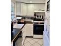 Functional kitchen featuring white cabinets, black appliances, and tile floors at 1025 Carolina Rd. # F2, Conway, SC 29526