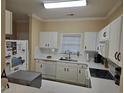 Well-equipped kitchen featuring white cabinets, updated countertops, and modern appliances at 5801 Oyster Catcher Dr. # 413, North Myrtle Beach, SC 29582