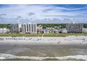 Aerial view of oceanfront property with beach, high-rise buildings, and lush greenery at 4105 S Ocean Blvd. S # 102, North Myrtle Beach, SC 29582