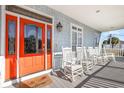 Front porch with orange door and white rocking chairs at 204 5Th Ave. N, North Myrtle Beach, SC 29582