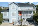 Two-story light blue house with a large front porch and white railings at 204 5Th Ave. N, North Myrtle Beach, SC 29582