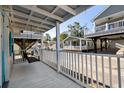 White porch with a wooden swing and white railing at 6001 - 1749 S Kings Hwy., Myrtle Beach, SC 29575