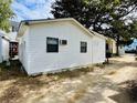 Side view of a white cottage with mature trees nearby at 6001 - M26 S Kings Hwy., Myrtle Beach, SC 29575