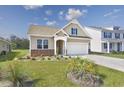 Tan house with a two-car garage and manicured lawn at 6041 Mcclain Ct., Little River, SC 29566