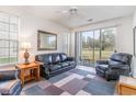 Spacious living room with leather furniture and golf course view at 646 River Oak Dr. # 47-A, Myrtle Beach, SC 29579