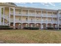 Front view of a two story condo building with white columns and balconies at 679 Riverwalk Dr. # 202, Myrtle Beach, SC 29579