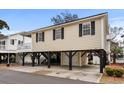 Elevated light beige house with a garage and a deck at 6001 - 8039 S Kings Hwy., Myrtle Beach, SC 29575