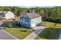Aerial view of a two-story light blue house with a side yard and driveway at 1315 Bermuda Grass Dr., Myrtle Beach, SC 29579
