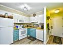 Small kitchen with teal cabinets and white appliances at 4305 S Ocean Blvd. # 205, North Myrtle Beach, SC 29582