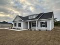 Newly constructed home with gray siding, black shutters, and a covered porch at 3854 Red Bluff Rd., Loris, SC 29569