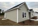 Side view of a tan house, showcasing its vinyl siding and window at 3858 Red Bluff Rd., Loris, SC 29569