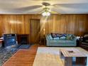 Living room with wood paneled walls, a wood burning fireplace, and comfy seating at 1064 Heritage Rd., Loris, SC 29569