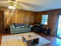Living Room with wood paneled walls, a large window, and comfortable seating at 1064 Heritage Rd., Loris, SC 29569
