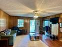 Living room with wood paneling, comfy seating, and a large TV at 1064 Heritage Rd., Loris, SC 29569