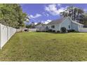Large backyard with green grass, white fence, and deck at 153 Garden Ave., Georgetown, SC 29440