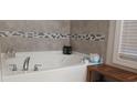 Bathroom featuring a large soaking tub and tile surround at 2808 Stellar Loop, Myrtle Beach, SC 29577