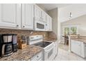 White kitchen cabinets, granite countertops, and appliances at 1025 Algonquin Dr. # 15-E, Pawleys Island, SC 29585