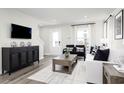 Living room features a white couch, black accent chairs, and a large TV at 2740 Rowyn St., Longs, SC 29568