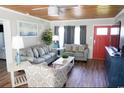 Living room with gray sofas, wood-paneled ceiling, and large TV at 309 21St Ave. N, North Myrtle Beach, SC 29582