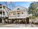 Two-story beach house with a wrap-around porch and parking underneath at 6001 - N120 S Kings Hwy., Myrtle Beach, SC 29575