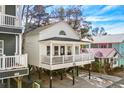 White beach house on stilts with parking underneath and a golf cart at 6001 - N120 S Kings Hwy., Myrtle Beach, SC 29575