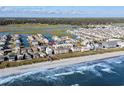 Wide aerial showcasing beachfront property, waterway, and nearby town at 4801 North Ocean Blvd. # 3N, North Myrtle Beach, SC 29582