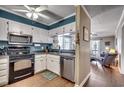 Kitchen with white cabinets, black appliances, and teal walls at 814 N Waccamaw Dr. # 311, Garden City Beach, SC 29576