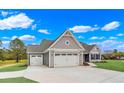 New home exterior with gray siding, double garage and landscaped yard at 550 Wagon Wheel Trail, Calabash, NC 28467