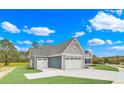 New home exterior with gray siding, double garage and landscaped yard at 550 Wagon Wheel Trail, Calabash, NC 28467