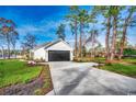 Back exterior view showcasing the driveway, garage, and backyard space at 157 Bay Circle Dr., Loris, SC 29569