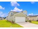 Two-story house with green siding, white garage door, and landscaping at 420 Ribbon Rail Way, Loris, SC 29569