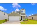 Two-story house with green siding, black front door, and landscaping at 420 Ribbon Rail Way, Loris, SC 29569