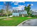 Two-story light blue house with stone accents and landscaping at 713 Shell Point Ct., Longs, SC 29568