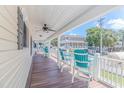 Relaxing front porch with teal chairs and ceiling fan at 6001 - 8016 S Kings Hwy., Myrtle Beach, SC 29575