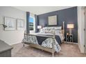 Main bedroom with a post bed, blue accent wall, and carpet flooring at 651 Wallace Dr., Little River, SC 29566