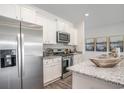 Modern kitchen with white cabinets, granite countertops, and stainless steel appliances at 651 Wallace Dr., Little River, SC 29566