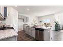 Modern kitchen with island, granite counters, and stainless steel appliances at 7302 Meadow Walk Loop, Loris, SC 29569
