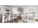 Modern kitchen with gray cabinets, granite counters, and an island at 7302 Meadow Walk Loop, Loris, SC 29569