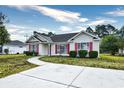 House exterior featuring a beige vinyl-sided home with red shutters and a curved driveway at 4336 Summitt Trail, Myrtle Beach, SC 29579