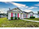 House exterior featuring a beige vinyl-sided home with red shutters and landscaping at 4336 Summitt Trail, Myrtle Beach, SC 29579