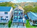 Two-story home with gray siding, deck, and surrounding houses at 6001 - 1191 S Kings Hwy., Myrtle Beach, SC 29575