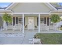 Inviting front porch with white rocking chairs, hanging ferns, and decorative accents at 113 Edwards Ln., Longs, SC 29568