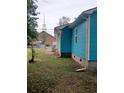 Side view of teal house with brick foundation and yard at 1519 Racepath Ave., Conway, SC 29526