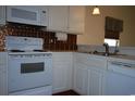 White cabinets, copper backsplash, and modern appliances at 1990 Cross Gate Blvd. # 202, Surfside Beach, SC 29575