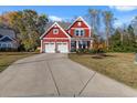 Red two-story house with white trim, two-car garage, and landscaped yard at 273 Board Landing Circle, Conway, SC 29526