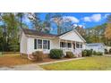 Simple white house with a covered porch and green shutters at 1002 Palmer Dr., Calabash, NC 28467