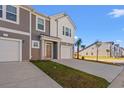 Two-story townhome with gray and white siding, two-car garage, and a stop sign at 237 Sandridgebury Dr. # 58, Little River, SC 29566